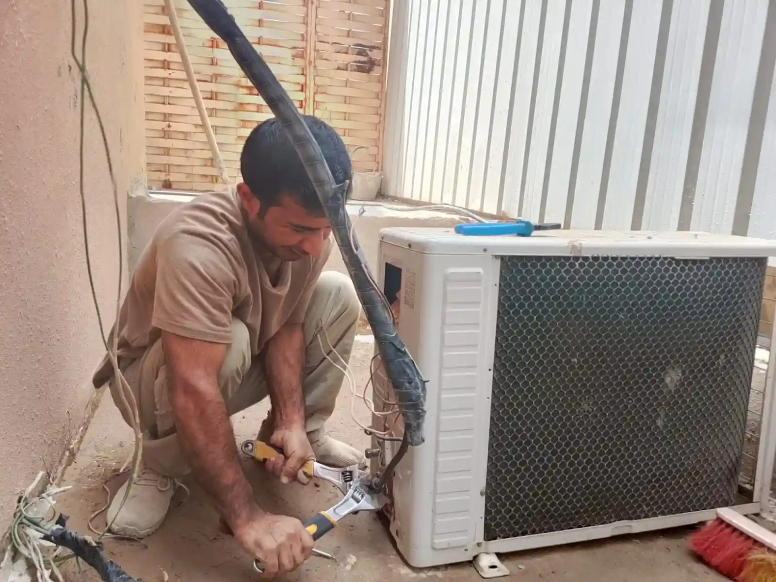 محمد نبيل أثناء تنظيف وصيانة مكيف في حي العليا الرياض