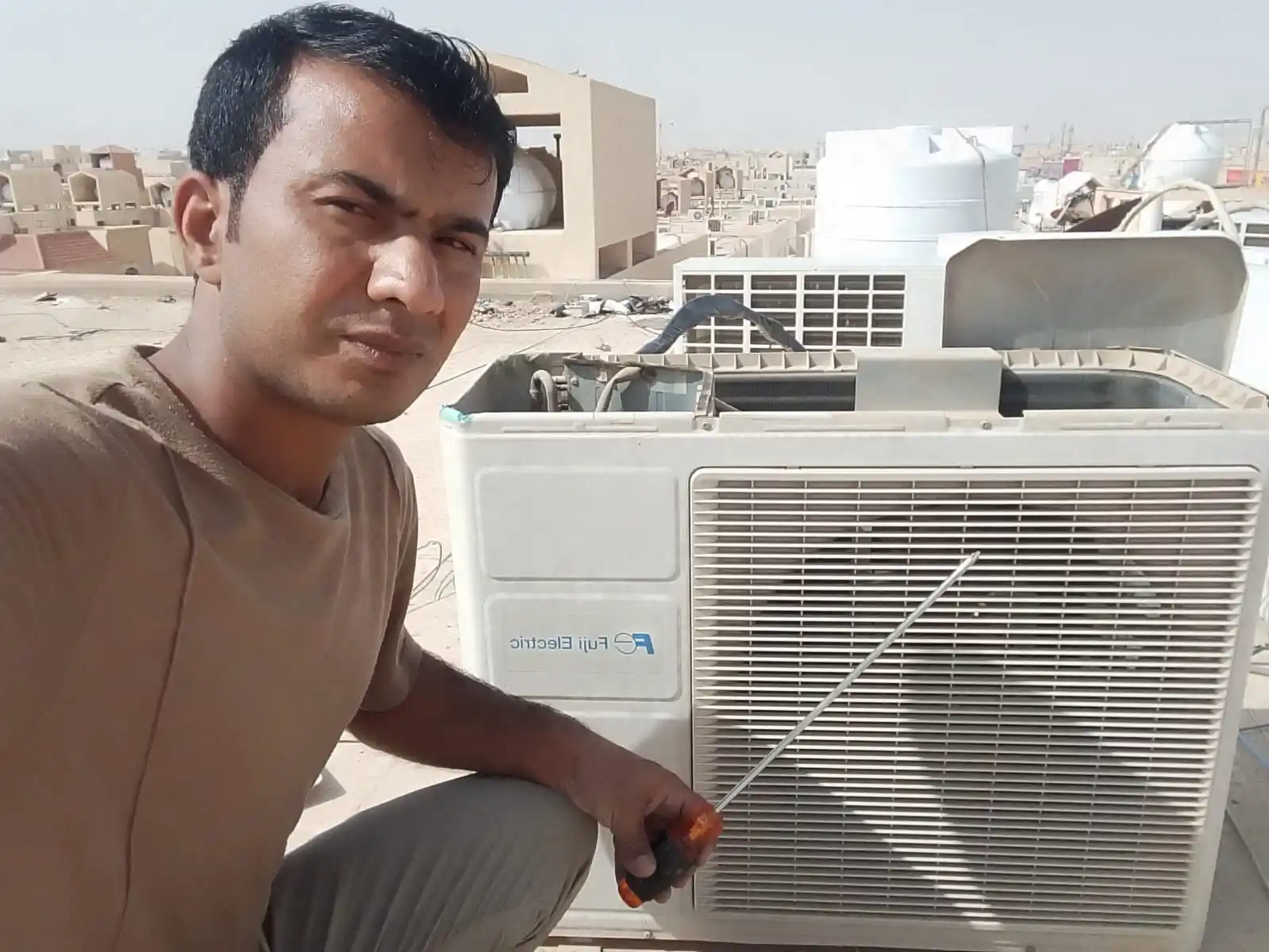 محمد نبيل أثناء إصلاح مكيف طوارئ في حي عرقة الرياض